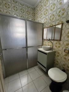 ein Badezimmer mit Toilette und Waschbecken in der Unterkunft Casa aconchegante na Vila Tupi - Perto da Praia in Praia Grande
