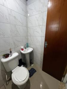 ein Badezimmer mit Toilette und Waschbecken in der Unterkunft Casa aconchegante na Vila Tupi - Perto da Praia in Praia Grande + 4 Fotos