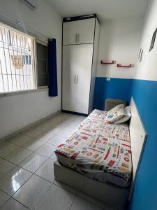 ein Schlafzimmer mit einem Bett und einem Schrank darin in der Unterkunft Casa aconchegante na Vila Tupi - Perto da Praia in Praia Grande