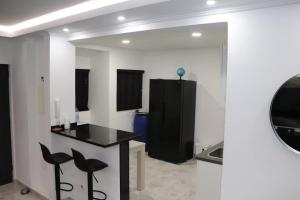 una cucina con bancone nero e sgabelli neri di Micaya a Praia