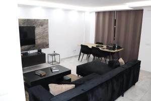 un soggiorno con un divano nero e un tavolo di Micaya a Praia