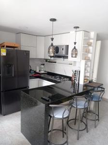 a kitchen with a black counter and a refrigerator at My Bunker in Cali
