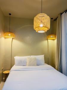 a bedroom with a bed with two lights above it at Arko Villa in Katangawan +15 photos