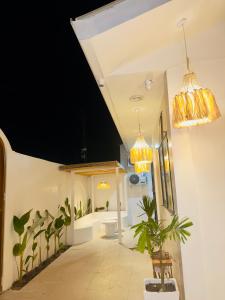 a hallway with potted plants and two chandeliers at Arko Villa in Katangawan