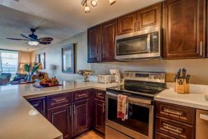 een keuken met houten kasten en een kookplaat met oven bij Lauloa 102 in Wailuku