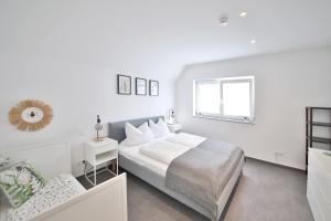 een witte slaapkamer met een bed en een raam bij FeWo D&Y -barrierefrei- in Ubstadt-Weiher