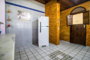 a white refrigerator in a kitchen with a door at Casa de veraneio de frente à praia de Tabatinga - RN in Nísia Floresta