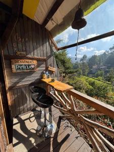 un patio con una mesa y 2 taburetes en una cubierta en Cabaña en la Calera BersaNina Con Sauna a Vapor, en La Calera 28 fotos más