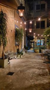 a large lobby with potted plants and tables and lights at La Rozada Suites in Corrientes