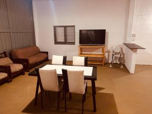 een woonkamer met een tafel en een tv bij Doma y folklore in Colonia Caroya