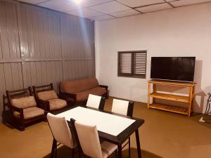 een woonkamer met een tafel en een televisie bij Doma y folklore in Colonia Caroya