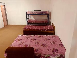 een kamer met drie bedden en een tafel met een deken bij Doma y folklore in Colonia Caroya