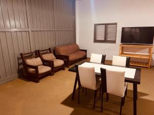 een woonkamer met een tafel, stoelen en een televisie bij Doma y folklore in Colonia Caroya