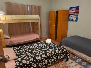 Patagonia Mágica في بونتا أريناس: غرفة بها أسرّة بطابقين وسرير وخزانة ملابس