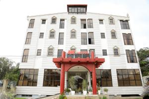 阿瓦萨MK Hotel的一座白色建筑，前面有一个红色拱门。