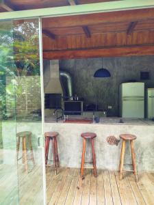 a group of stools sitting on a patio with a kitchen at Casa Laurus in São Sebastião +19 photos