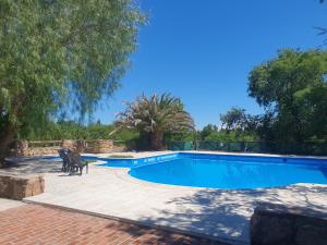 a swimming pool with two chairs next to it at El Aguaribay de los Nonos in Mina Clavero