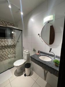 ein Badezimmer mit Toilette, Waschbecken und Spiegel in der Unterkunft Nosso Chalet in Lavras Novas
