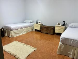 ein Zimmer mit zwei Betten und zwei Nachttischen in der Unterkunft Rincón del roble in Veinticinco de Mayo