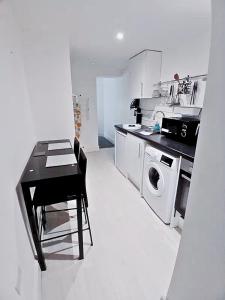 a kitchen with a table and a washing machine at Elegant Broadway Retreat w Parking & Dog Friendly in Broadway