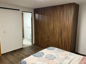 a bedroom with a bed and a wooden cabinet at Casa Cholula in La Concepción