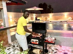 um homem parado em frente a uma grelha em Mdf Saloum em Poundiougne