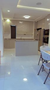 Una habitación con cocina con suelo y sillas blancas. en Gazyhomes1, en Lekki 2 fotos más
