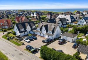 an aerial view of a town with cars parked in a parking lot at Küstennest in Wenningstedt