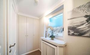 a bathroom with a window and a vase on a counter at Küstennest in Wenningstedt +39 photos