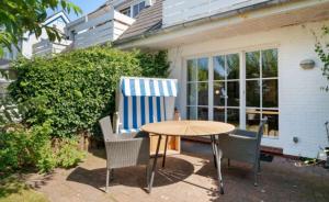 a table and chairs with a blue and white chair at Küstennest in Wenningstedt