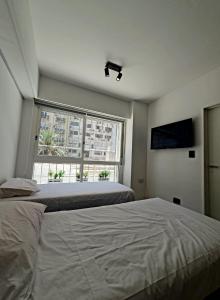 een slaapkamer met een groot bed en een raam bij Viamonte Che! in Buenos Aires