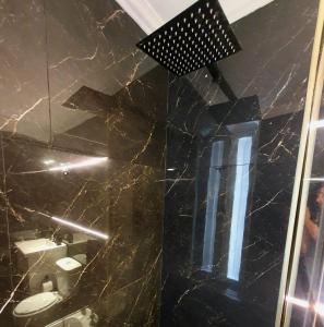 een badkamer met een zwarte marmeren vloer en een spiegel bij Viamonte Che! in Buenos Aires +9 foto's