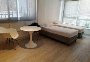 een slaapkamer met 2 bedden, een tafel en een raam bij Viamonte Che! in Buenos Aires