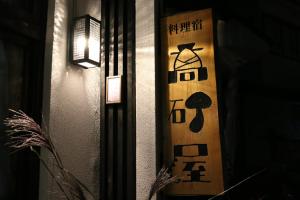 ein Snowboard mit asiatischem Schreiben an einer Wand in der Unterkunft Takasagoya Ryokan in Zao Onsen