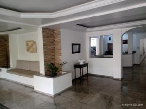 a living room with white walls and a ceiling at apartamento 1 quarto in Guarujá