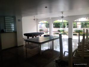 a dining room with a table and chairs and windows at apartamento 1 quarto in Guarujá