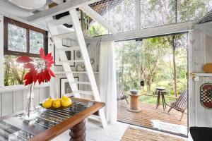 een kamer met een boomhut, een tafel en een ladder bij Pousada DVeras in Garopaba