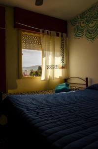 a bedroom with a bed in front of a window at Hospedaje Jazmin Cosquín in Cosquín
