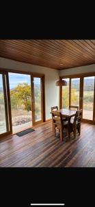 a dining room with a table and chairs and windows at Chalé Corumbau - Lapinha da Serra in Santana do Riacho