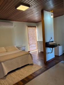 a bedroom with a bed and a wooden ceiling at Chalé Corumbau - Lapinha da Serra in Santana do Riacho