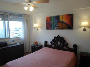 a bedroom with a bed and a painting on the wall at Radar Mirador Cabo Corrientes in Mar del Plata +137 photos
