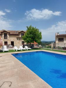 a swimming pool in front of a house at Hotel Apartamento Marouco in A Guarda