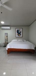 una camera da letto con un letto grande in una stanza bianca di Apartamentos Jireh a Quepos