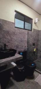 bagno con servizi igienici neri e lavandino di Apartamentos Jireh a Quepos Altre 12 foto