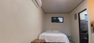 a bedroom with a bed in a white room at Apartamentos Jireh in Quepos