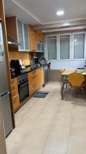 a kitchen with wooden cabinets and a table with chairs at MALÔ - Queluz in Queluz