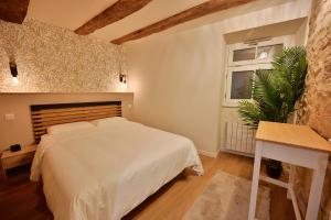 ein Schlafzimmer mit einem weißen Bett und einem Fenster in der Unterkunft Rez de chaussée appartement à Tournus - RIMA in Tournus