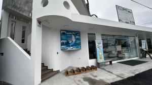 a white building with a bench in front of it at Suite Rosedelco in Puerto Villamil
