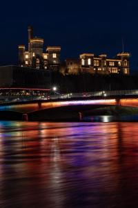 een brug over een rivier 's nachts met gebouwen bij River-View Loft, sleeps 4, with parking in Inverness
