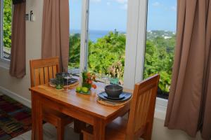 a dining room table with a view of the ocean at Memwa Villas in Castries